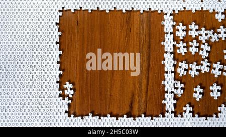 Incomplete jigsaw puzzle on wooden table Stock Photo