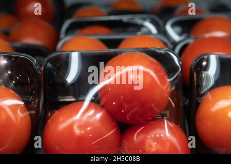 Tomatoes in plastic tray and plastic wrap packaging Stock Photo