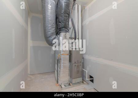 HVAC system inside a utility closet room with white markings on the wall Stock Photo