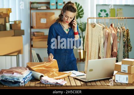 modern small business owner woman in the office talking on a smartphone. Stock Photo