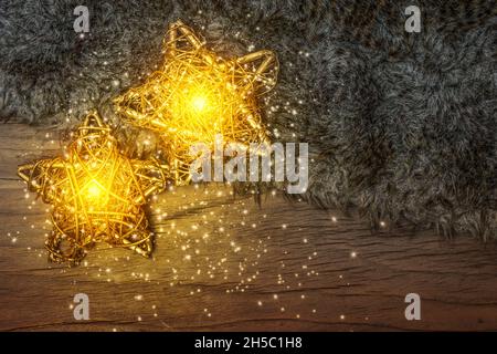Glowing Christmas stars on wood in the dark. Stock Photo