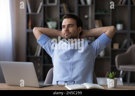 Happy young businessman relaxing in modern office room. Stock Photo