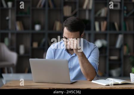 Stressed young businessman feeling unwell in office. Stock Photo