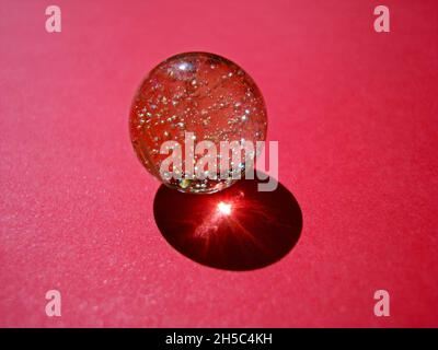 Marble ball on red background Stock Photo
