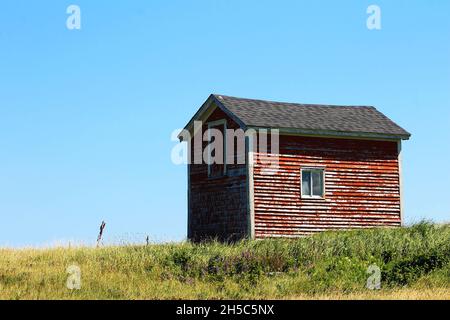 An old red barn on a grassy hill Stock Photo