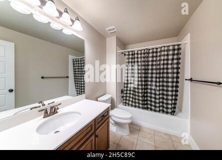 Traditional bathroom interior with checkered black and white shower curtain Stock Photo