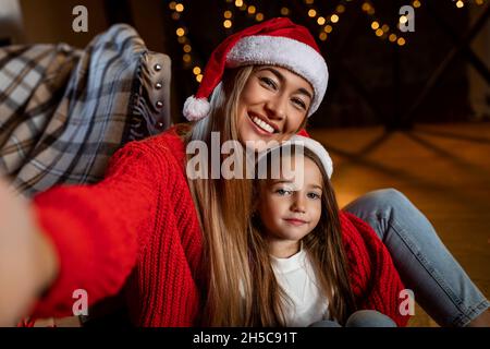 Pov of happy woman and daughter talking selfie at xmas Stock Photo