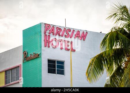 Miami Beach, USA - January 17, 2021: South Beach Collins Avenue road street with famous retro art deco Parisian Hotel in pink and turquoise green colo Stock Photo