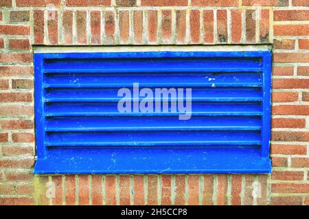 Blue ventilation duct in an industrial building Air intake and outtake of the ventilation system in an industrial building. Blue grille in a brick wal Stock Photo