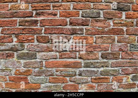 Wall of ancient red and grey bricks. Detail of the medieval brick wall of an old church in the north of the Netherlands Stock Photo