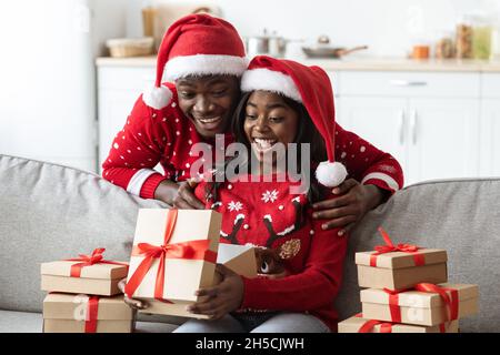 Excited african american family opening Christmas gifts together Stock Photo