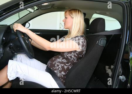 pregnant woman sitting buckled up in the car Stock Photo