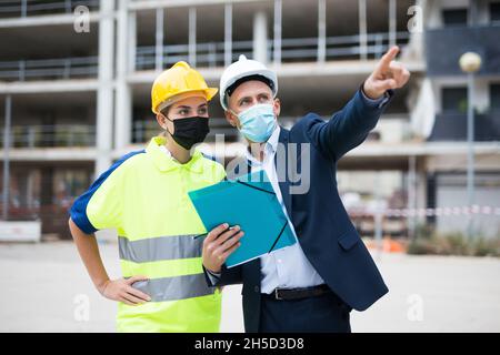 Civil engineers in masks checking work process Stock Photo