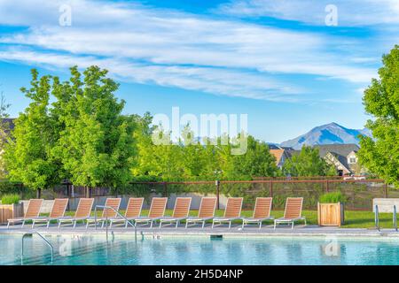 Lounge chairs on a public pool with wired fence at Daybreak, Utah Stock Photo