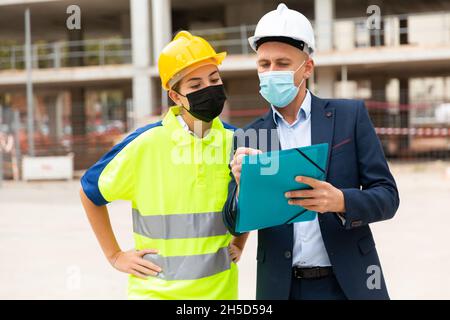 Civil engineers in masks checking work process Stock Photo