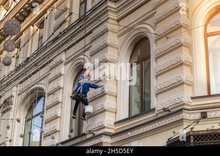 worker builder high-rise restores a historic building fasade  Stock Photo