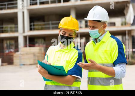 Civil engineers in masks checking work process Stock Photo