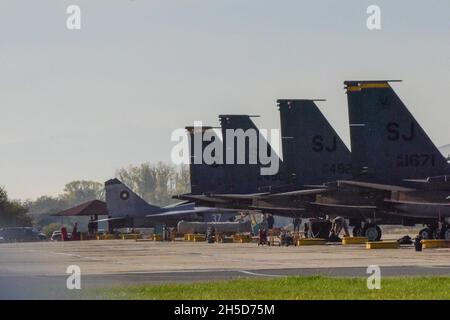 A Bulgarian Air Force MiG-29 aircraft sits next to F-15E Strike Eagles from the 336th Fighter Squadron, 4th Fighter Wing, Seymour Johnson Air Force Base, North Carolina, Graf Ignatievo Air Base, Bulgaria, Nov. 3, 2021. Castle Forge is a U.S. Air Forces Europe-Air Forces Africa-led, joint, multi-national operation. It demonstrates the joint force’s combined ability to respond in times of crisis with a flexible, reassuring presence (U.S. Air Force photo by Senior Airman Jessica Blair). Stock Photo