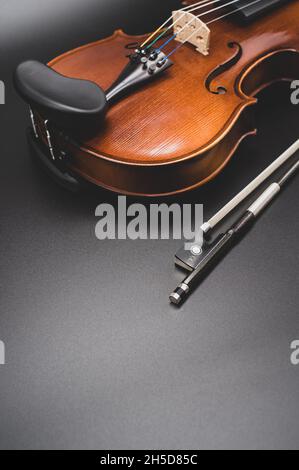 COMO, ITALY - Nov 07, 2021: top view of elegant acoustic violin and bow on a dark background Stock Photo