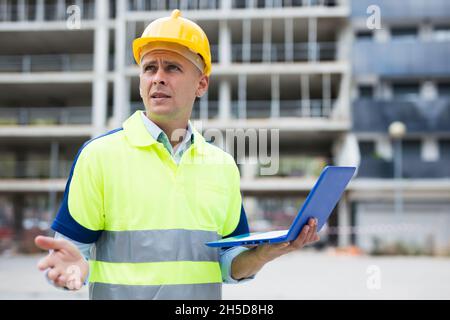 Builder talking about work at the laptop Stock Photo