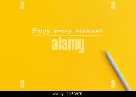 The text 'Enjoy every moment' on yellow background. Stock Photo