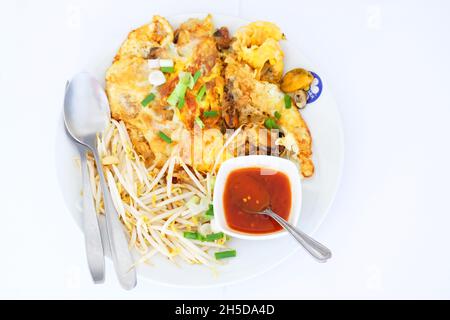 Fried mussels with egg and bean sprouts and tomato sauce in plate on white background Stock Photo