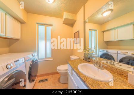 Small laundry and bathroom interior with narrow window Stock Photo