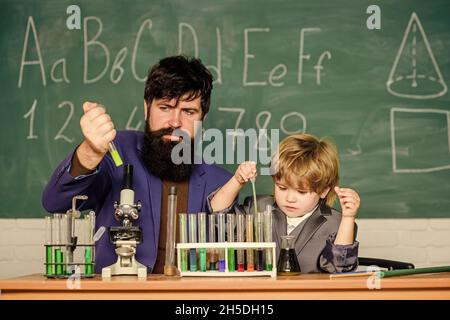 Powering Whats Next. small boy with teacher man. son and father at school. Modern Laboratory. Back to school. Biologist Conducts Experiments by Stock Photo
