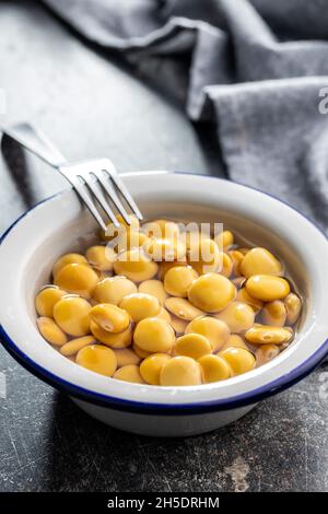 Pickled yellow Lupin Beans in bowl on kitchen table. Stock Photo