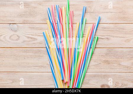 many multi-colored plastic tubes for cocktail on Colored background, top view. Stock Photo