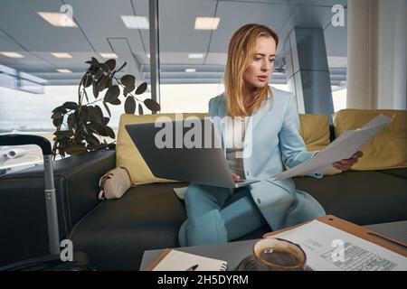 Serious concentrated businesswoman working in airport lounge Stock Photo
