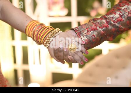 The hands of the couple touch. Both of them had a wedding ring on their left hand. Stock Photo