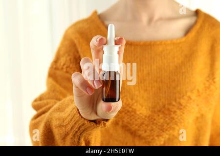 Woman holds nasal spray, close up and selective focus Stock Photo