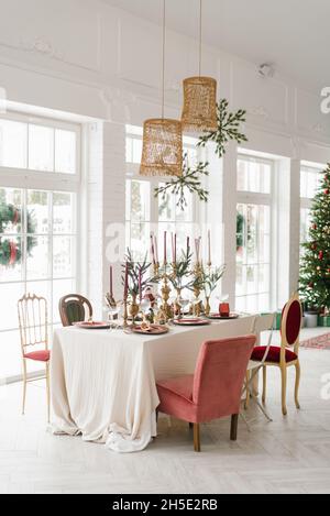 Beautifully laid table for Christmas dinner in a classic living room with French windows Stock Photo