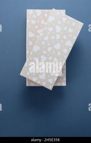 Beige gift boxes with pattern of hearts on a blue background Stock Photo