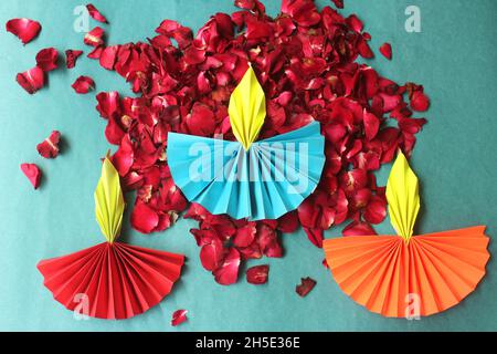 Colorful Diwali Lamps made with origami paper and fresh rose flower petals on blue background Stock Photo