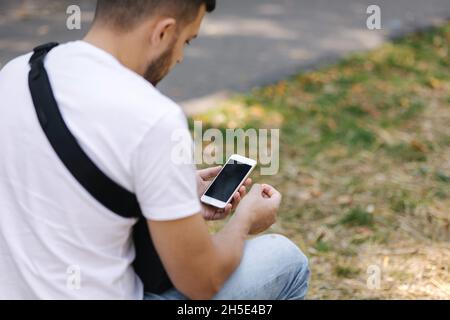 Man take SIM card from his phone. Back view of man sets his cellphone Stock Photo