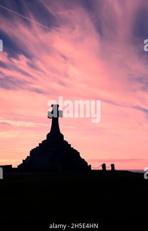 The imposing Newquay War memorial siulhouetted against a dramatic sunset in Cornwall. Stock Photo
