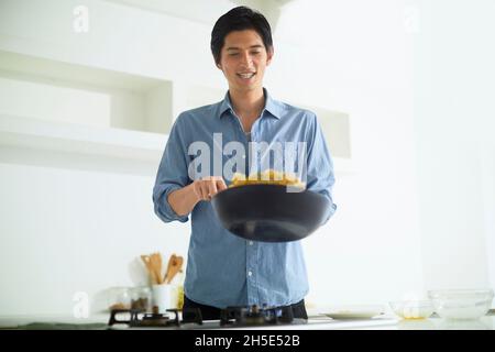 Japanese man cooking in the kitchen Stock Photo