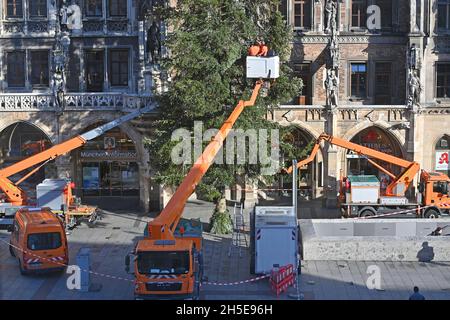 Workers on a lifting platform attach the Weihafterts lighting to the Weihaftertsbaum. Construction of the Christmas market on Marienplatz in Munich on November 9th, 2021.