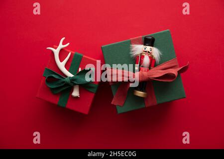 Hand made stylish Christmas gift box presents tied with red ribbon and a festive reindeer antler and toy Stock Photo