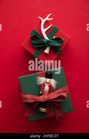 Hand made stylish Christmas gift box presents tied with red ribbon and a festive reindeer antler and toy Stock Photo