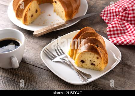 Traditional bundt cake piece with raisins on wooden table Stock Photo