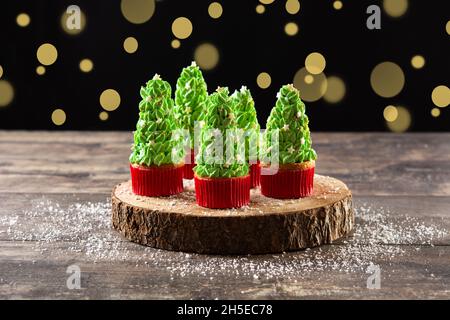 Christmas tree cupcakes on wooden table and bokeh background Stock Photo