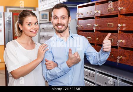 Loving happy couple choosing mailbox in hardware store Stock Photo