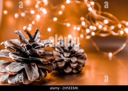 Christmas cones on a golden background with lights. Christmas background. Stock Photo