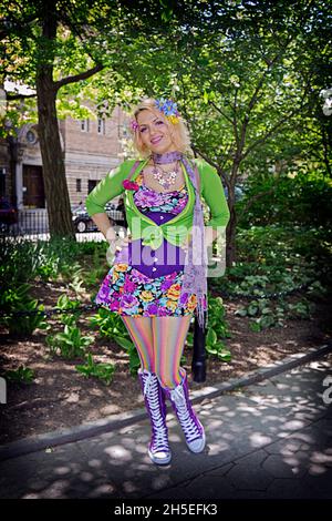 posed portrait of a beautiful young lady in a colorful out and with a unique personal style. In Washington Square Park in Manhattan, New York City. Stock Photo