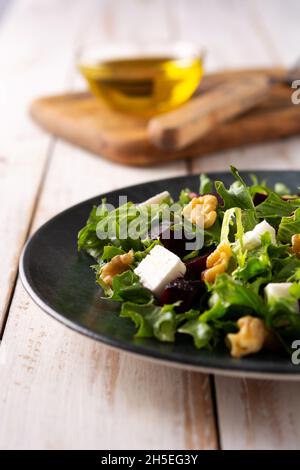 Beetroot salad with feta cheese,lettuce and walnuts on rustic wooden table Stock Photo
