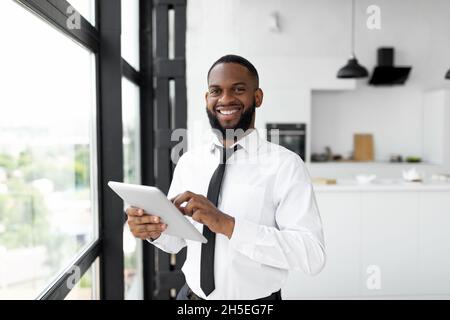 African American man using digital tablet looking at camera Stock Photo