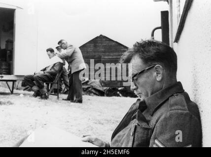 JOHN MILLS on set location candid in Rye, East Sussex England during filming of DUNKIRK 1958 director LESLIE NORMAN music Malcolm Arnold producer Michael Balcon Ealing Studios / Metro Goldwyn Mayer Stock Photo